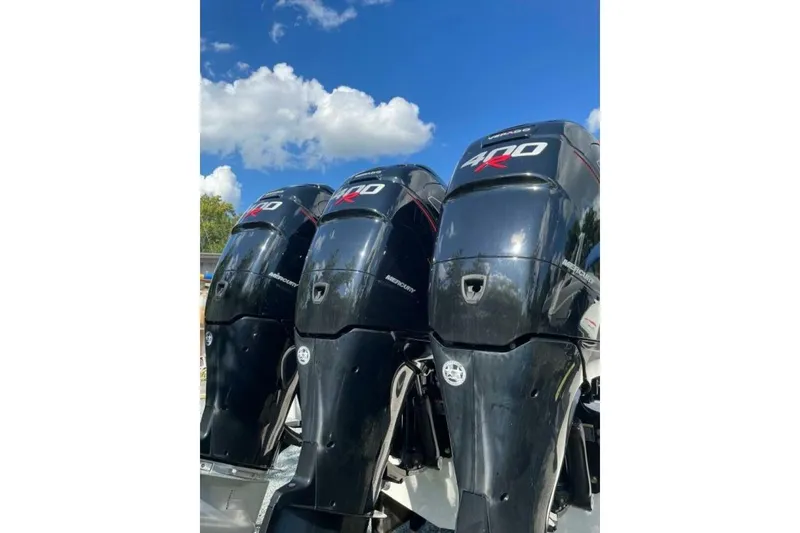 Slide: The Image of Triple Mercury 400R outboard engines on a 2022 Fountain 38 SC boat under a clear blue sky. - 13