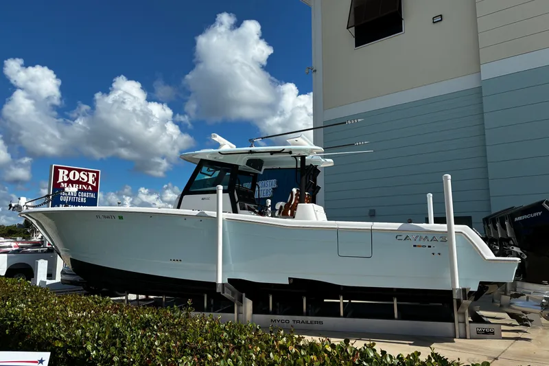Slide: The Image of 2024 Caymas 401 CC boat displayed at Rose Marina under a clear blue sky. - 1
