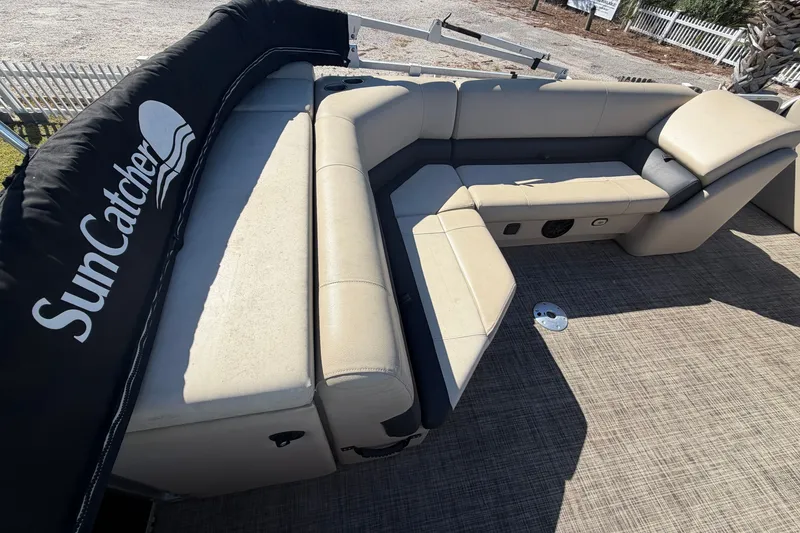 Slide: The Image of 2020 SunCatcher V322C boat interior with beige seating and SunCatcher branding. - 21