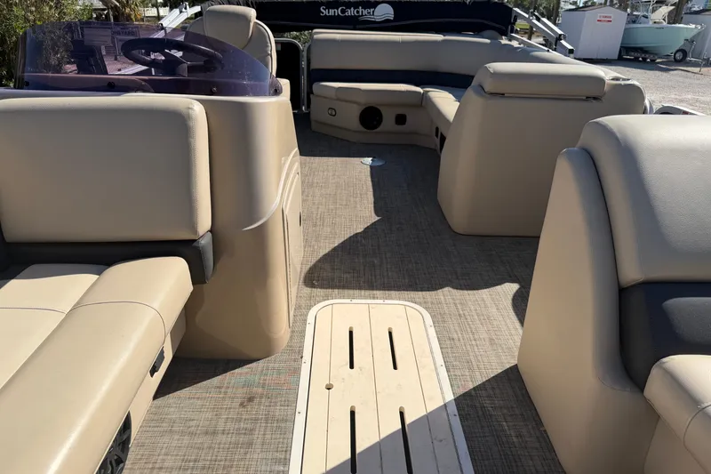 Slide: The Image of Interior of a 2020 SunCatcher V322C pontoon boat with beige seating and steering console. - 8