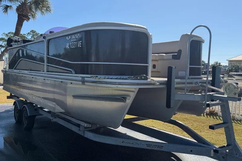 Slide: The Image of 2020 SunCatcher V322C pontoon boat on trailer, parked outdoors under clear sky. - 6