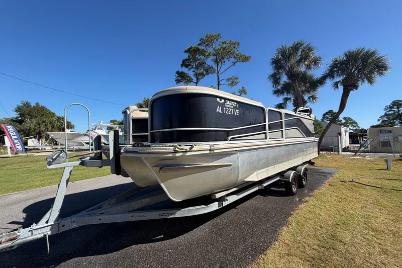 Slide: The Image of 2020 SunCatcher V322C pontoon boat on trailer, parked outdoors under clear blue sky. - 2