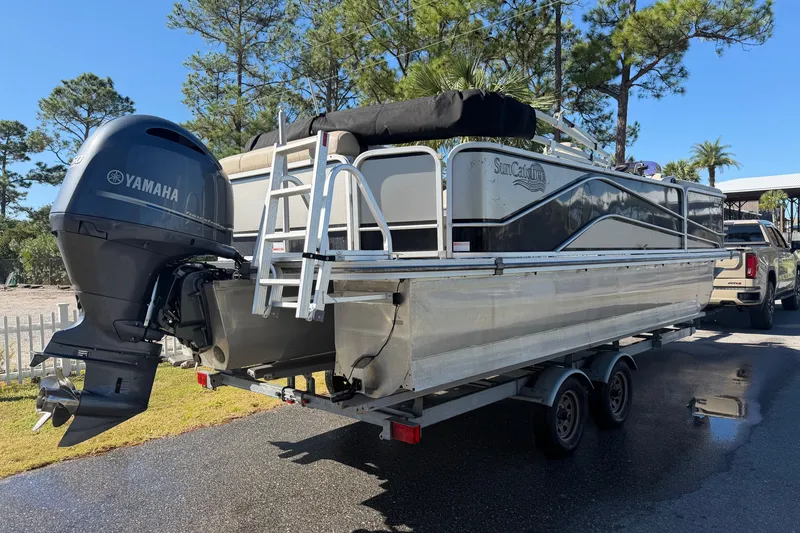 The Image of 2020 SunCatcher V322C pontoon boat with Yamaha motor on trailer, parked outdoors. - 0