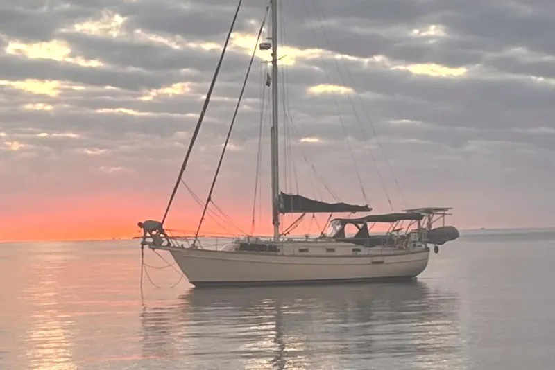 The Image of Sailboat Island Packet 35, 1990 model, anchored at sunset with cloudy sky. - 1