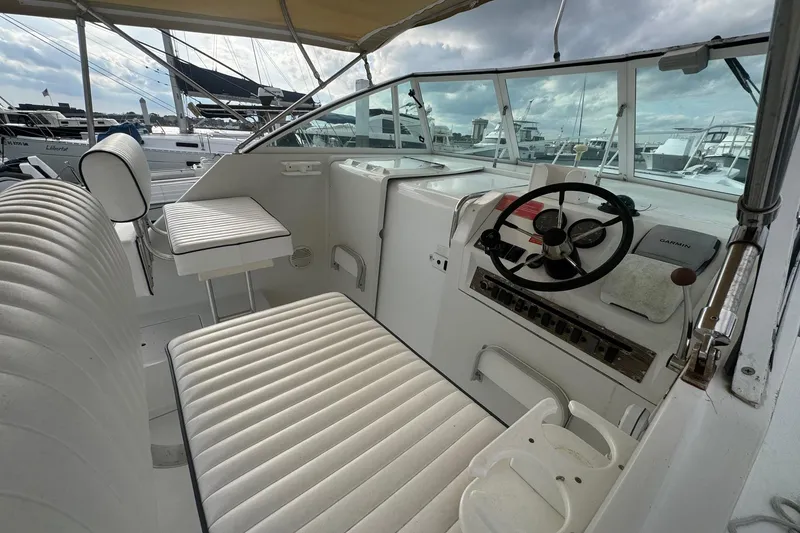 Slide: The Image of 2000 Mainship Pilot 30 boat cockpit with steering wheel and cushioned seating. - 16
