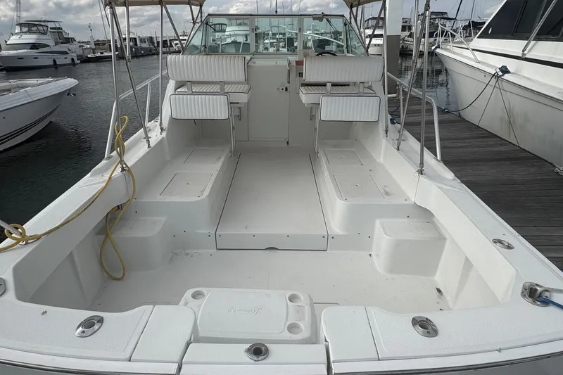 Slide: The Image of 2000 Mainship Pilot 30 boat docked, featuring spacious seating and clean deck design. - 8