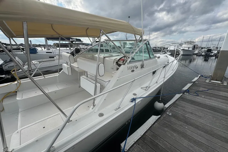 Slide: The Image of 2000 Mainship Pilot 30 docked at marina under cloudy skies. - 9
