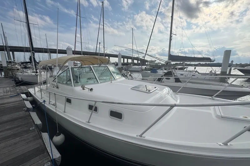 Slide: The Image of 2000 Mainship Pilot 30 docked at marina under cloudy sky. - 12