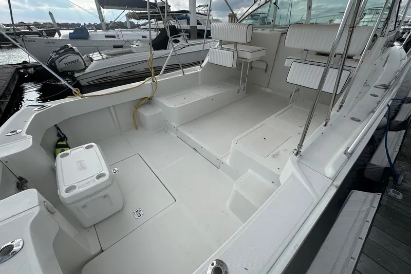 Slide: The Image of 2000 Mainship Pilot 30 boat interior with seating and storage, docked at marina. - 15