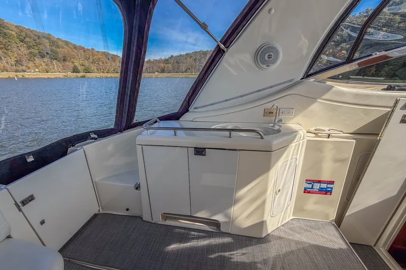 Slide: The Image of 2005 Cruisers Yachts 370 Express interior with sink, lake view, and wooded shoreline. - 18