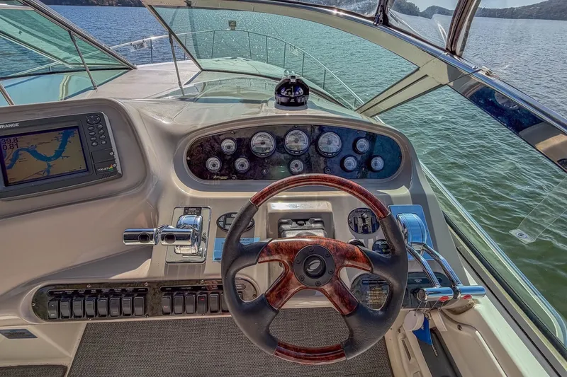 Slide: The Image of 2005 Cruisers Yachts 370 Express helm with navigation system and wooden steering wheel. - 21