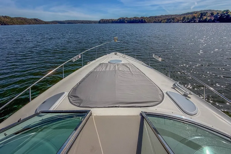 Slide: The Image of 2005 Cruisers Yachts 370 Express on serene lake with scenic forested shoreline. - 19