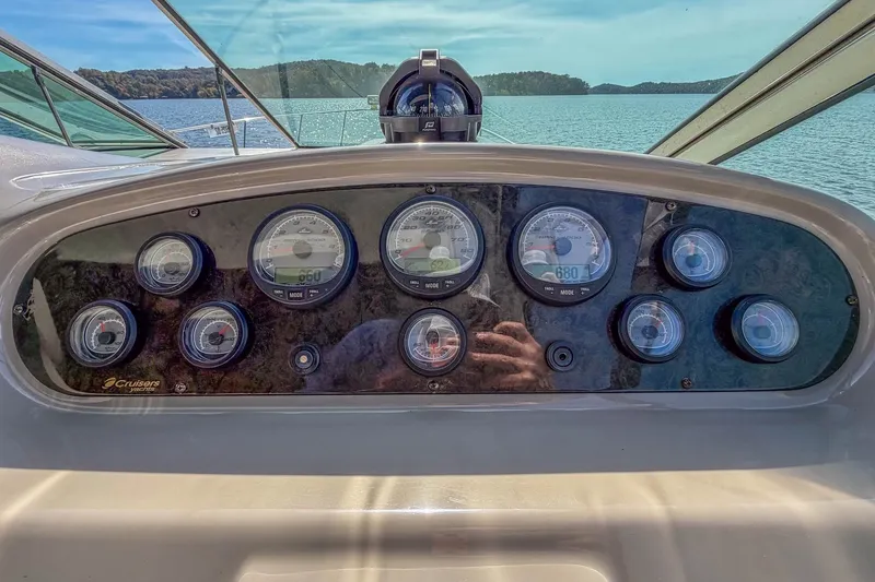 Slide: The Image of Dashboard of 2005 Cruisers Yachts 370 Express with gauges, overlooking serene lake view. - 22