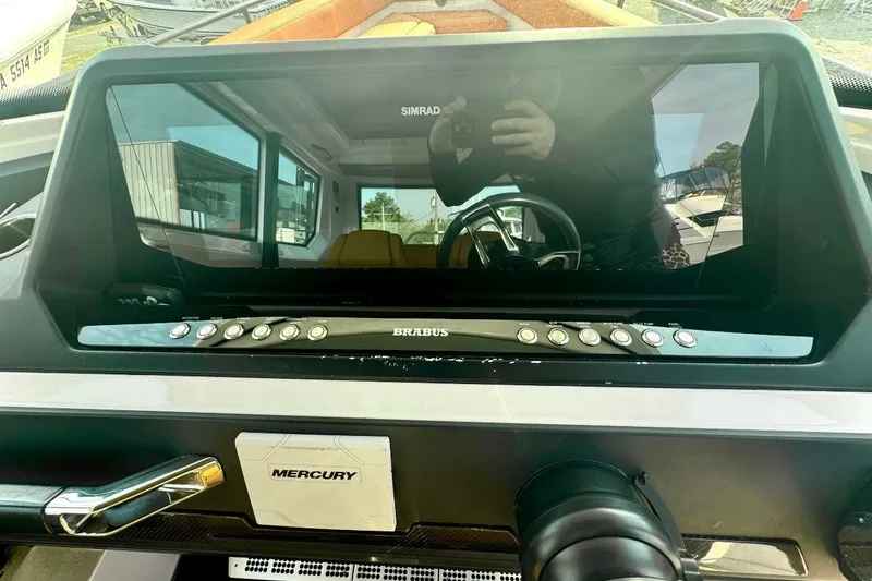 Slide: The Image of 2021 Axopar Brabus 28 Cabin dashboard with Simrad display and Mercury controls. - 20
