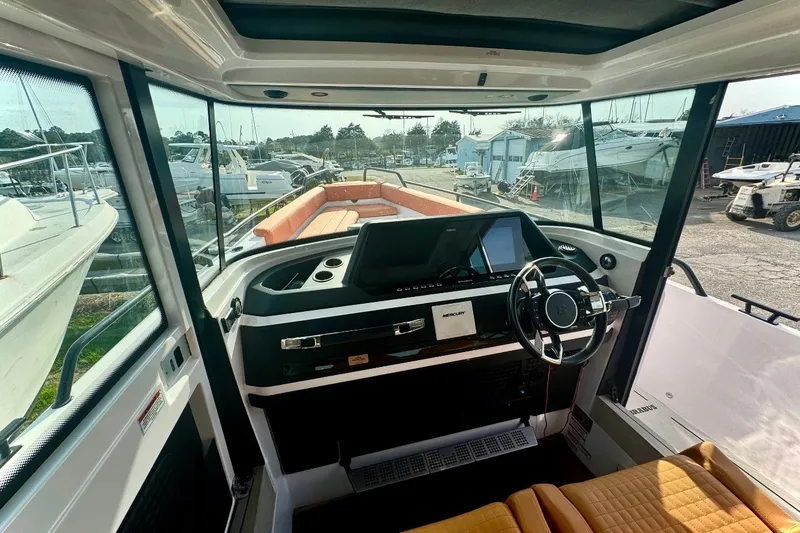 Slide: The Image of Interior view of 2021 Axopar Brabus 28 Cabin boat with modern dashboard and steering wheel. - 18