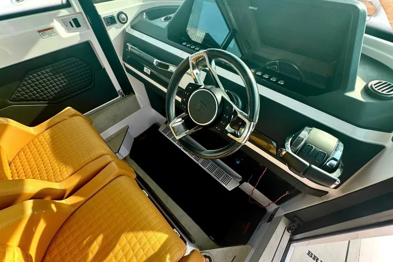 Slide: The Image of Interior of 2021 Axopar Brabus 28 Cabin with orange seats and modern dashboard. - 19
