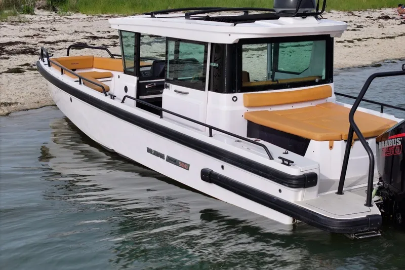 Slide: The Image of 2021 Axopar Brabus 28 Cabin boat docked on a sandy beach. - 14