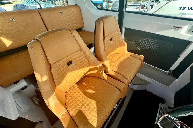 Slide: The Image of Luxurious interior of 2021 Axopar Brabus 28 Cabin with tan quilted seats. - 23
