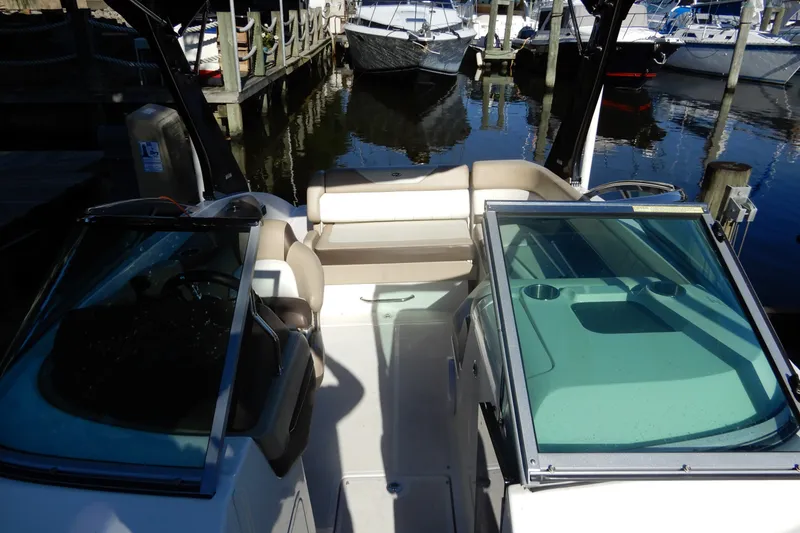 Slide: The Image of 2013 Regal 24 FasDeck boat interior at marina, featuring seating and windshield. - 19