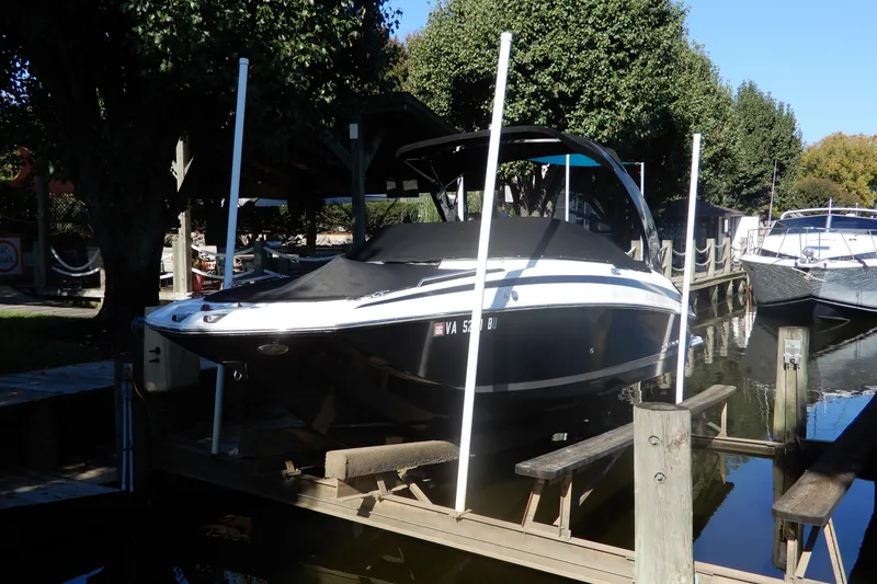 Slide: The Image of 2013 Regal 24 FasDeck boat docked in a serene marina setting. - 2