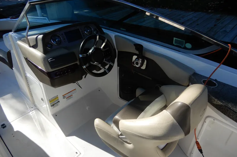 Slide: The Image of 2013 Regal 24 FasDeck boat cockpit with steering wheel and dashboard controls. - 8