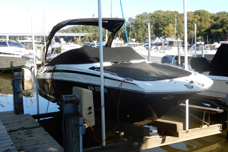 Slide: The Image of 2013 Regal 24 FasDeck boat docked at marina with cover on. - 1