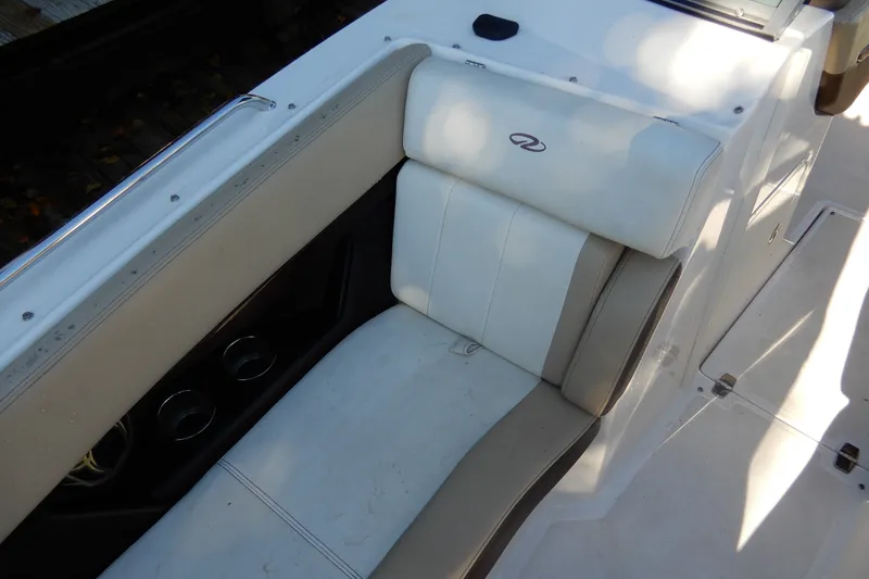 Slide: The Image of 2013 Regal 24 FasDeck boat interior seating with cup holders and white upholstery. - 15
