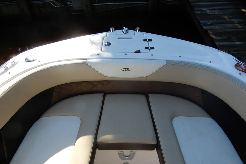 Slide: The Image of 2013 Regal 24 FasDeck boat interior with cushioned seating and storage compartment. - 16
