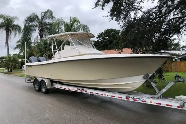 The Image of 2004 Contender 31 Fisharound boat on trailer, parked near palm trees. - 0