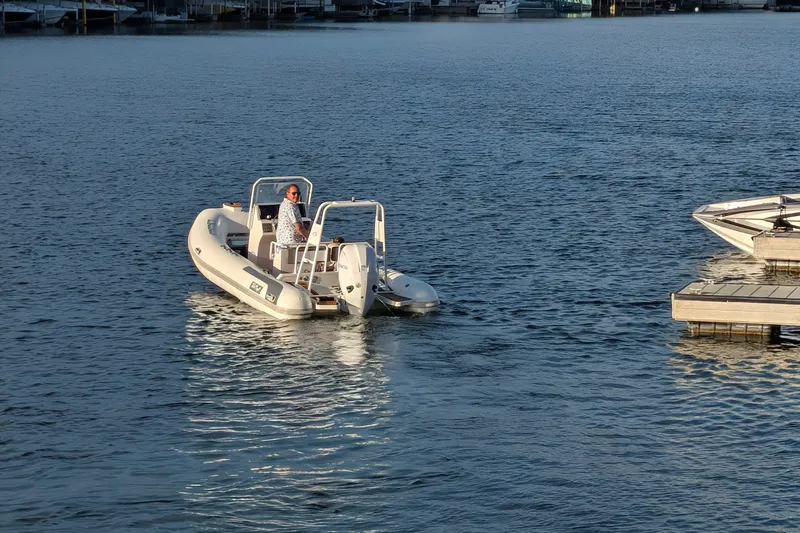 Slide: The Image of Tide Craft Sanibel 17 Demo Boat 2027 on calm water near dock. - 15