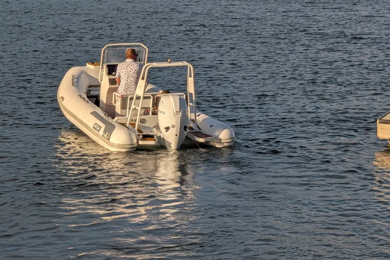 Slide: The Image of Tide Craft Sanibel 17 Demo Boat 2027 on water, rear view with driver. - 16
