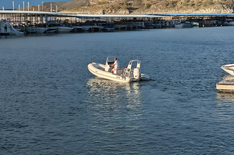 Slide: The Image of Tide Craft Sanibel 17 Demo Boat 2027 on a serene lake near docks. - 14
