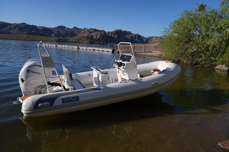 The Image of 2026 Tide Craft Sanibel 17 boat with Tohatsu engine on a serene lake. - 0