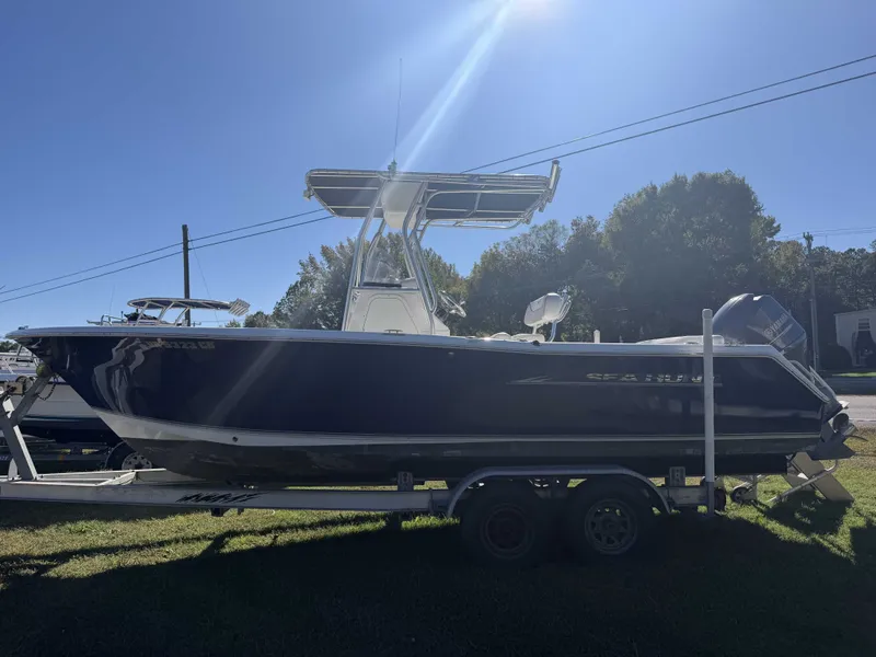 Slide: The Image of A blue 2013 Sea Hunt Ultra 225 boat on a trailer outdoors. - 2
