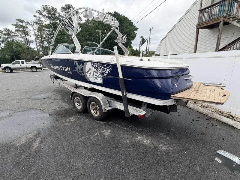 Slide: The Image of A 2008 MasterCraft X-45 boat on a trailer, featuring a blue hull and white deck. - 1