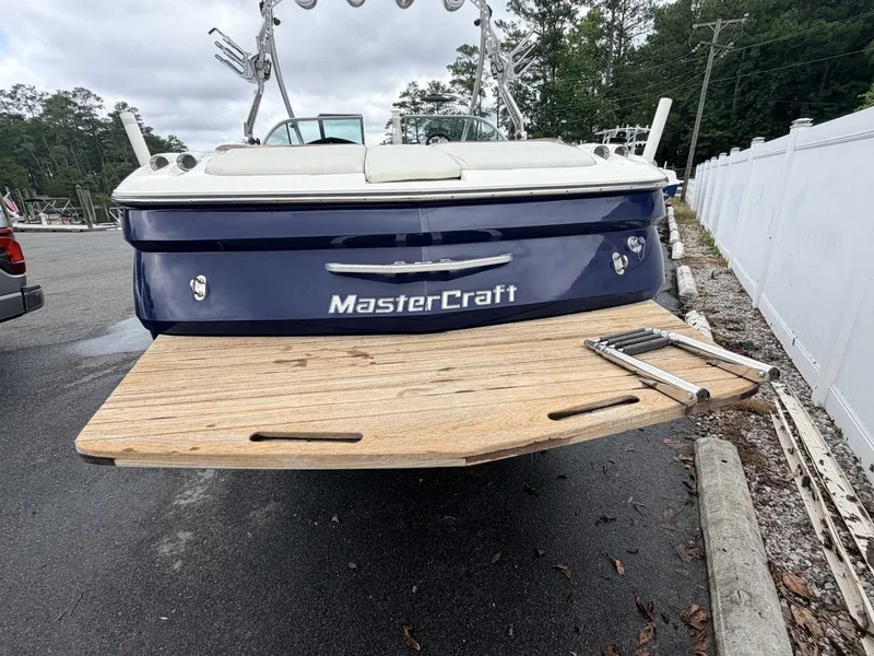 Slide: The Image of The image shows the rear of a blue MasterCraft X-45 boat with a wooden platform. - 4