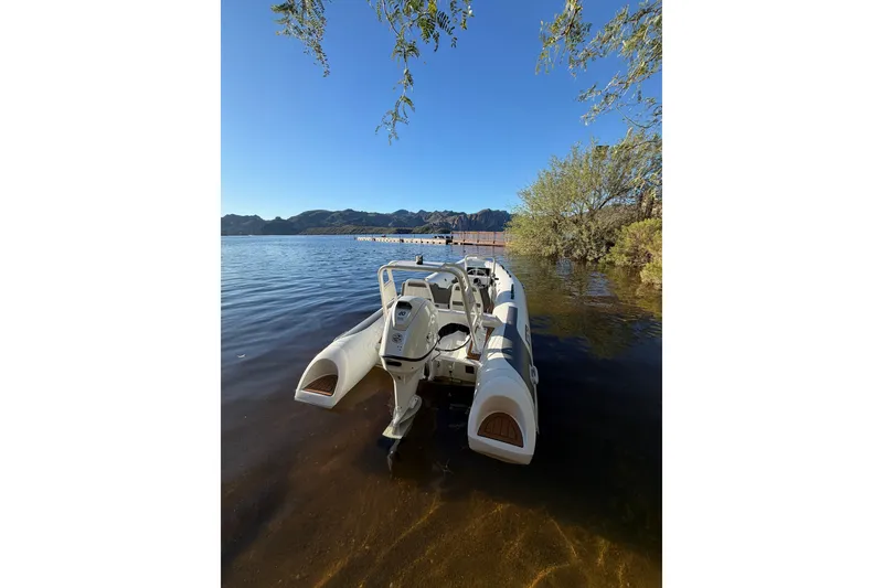 Slide: The Image of Tide Craft Coronado 14 boat on a serene lake, 2027 model, surrounded by nature. - 2