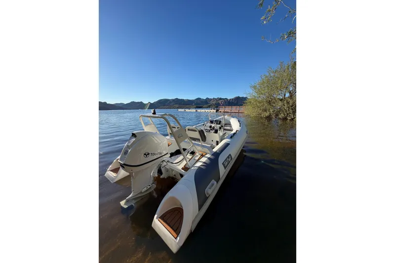 Slide: The Image of 2027 Tide Craft Coronado 14 boat on a serene lake with clear blue sky. - 3