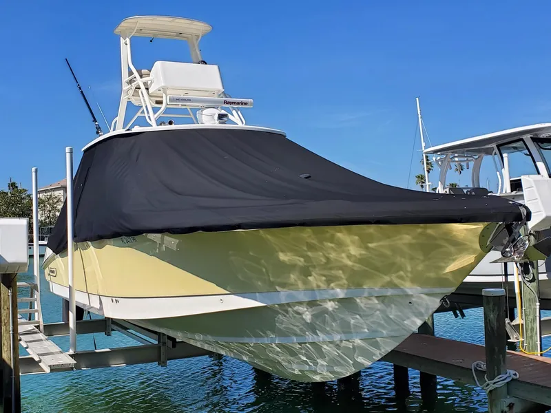 The Image of Ein Boston Whaler 370 Outrage von 2014 liegt auf einem Bootslift. Es hat eine schwarze Abdeckung. - 0