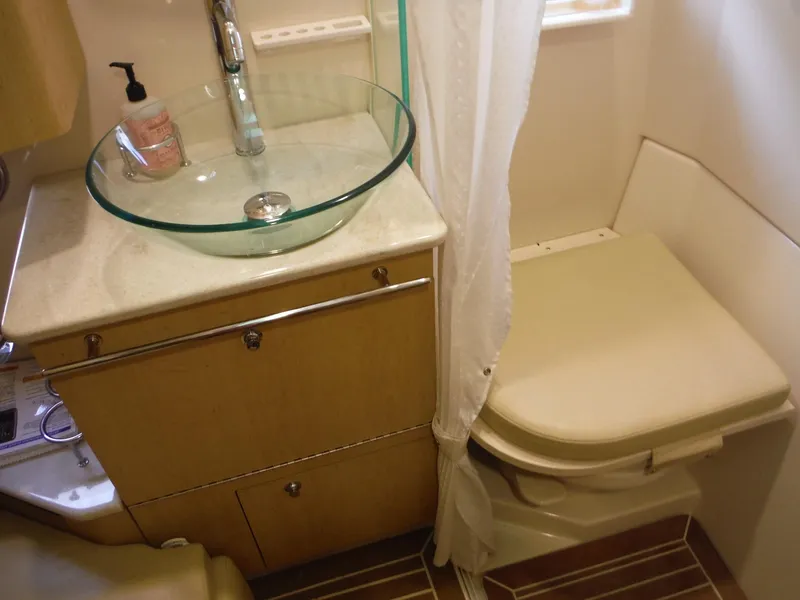 Slide: The Image of Das Bild zeigt ein Badezimmer auf einem Boot mit einem Glaswaschbecken und einer Toilette. - 30