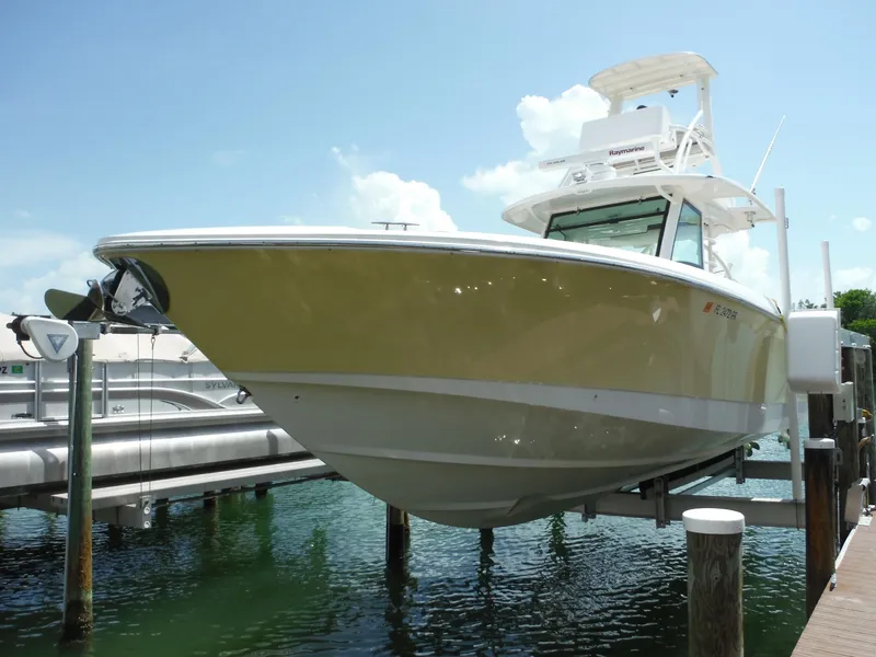 Slide: The Image of Ein Boston Whaler 370 Outrage von 2014 auf einem Bootslift über dem Wasser. - 1