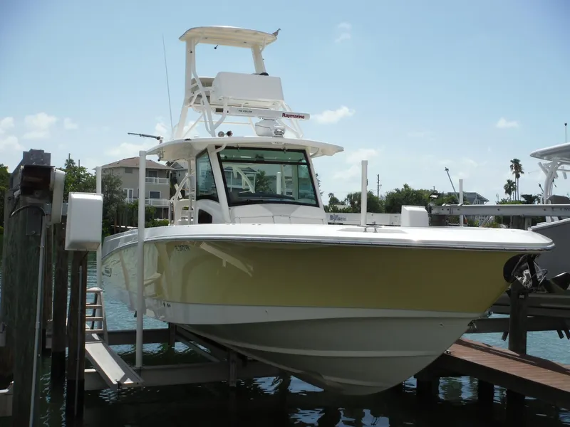 Slide: The Image of Ein Boston Whaler 370 Outrage von 2014 auf einem Bootslift, mit gelbem Rumpf und T-Tops. - 8