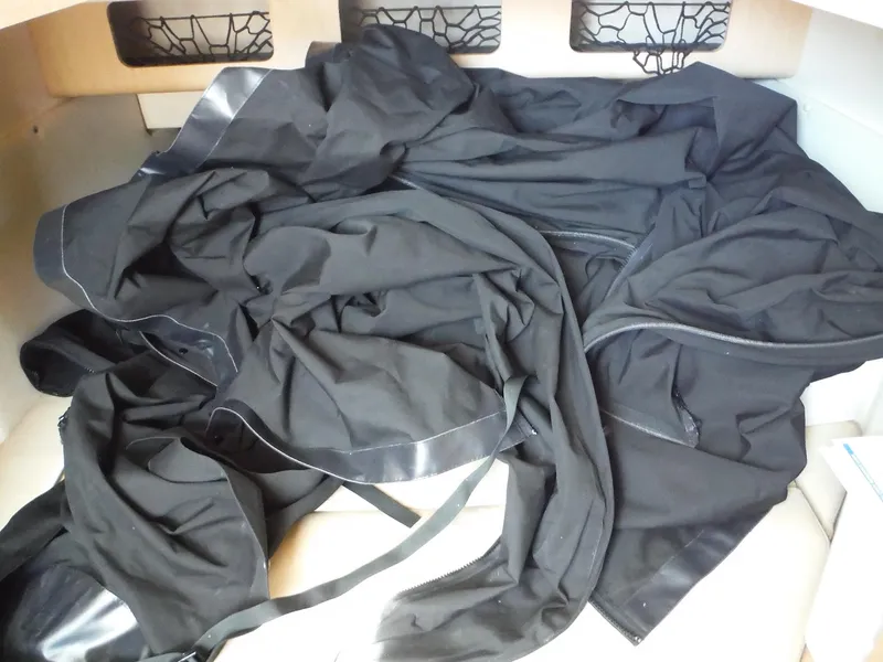 Slide: The Image of Ein schwarzes Tuch liegt in einem Boot mit weißen Wänden und Netztaschen. - 32