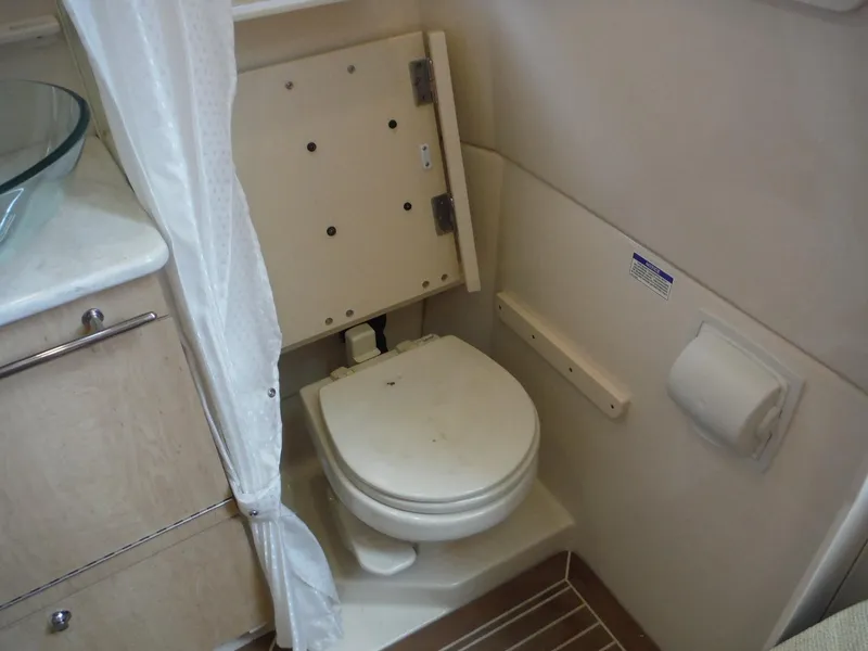 Slide: The Image of Ein Badezimmer mit einer Toilette, einem Duschvorhang und einem Waschbecken in einem Boot. - 27
