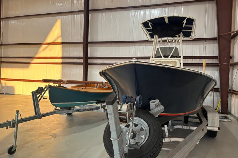Slide: The Image of 1982 Shamrock 200 Open boat on trailer in warehouse, alongside smaller boat. - 3