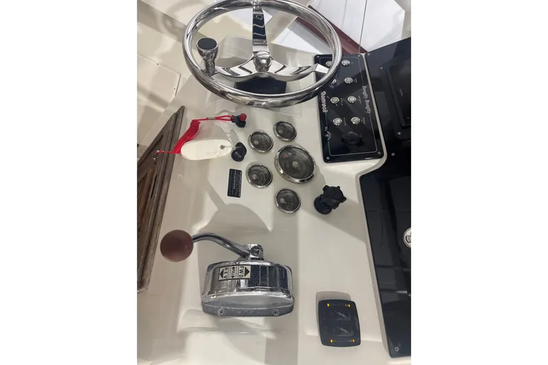 Slide: The Image of 1982 Shamrock 200 Open boat dashboard with steering wheel and control panel. - 6