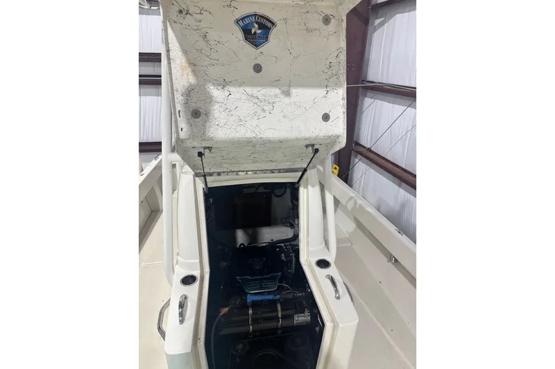 Slide: The Image of 1982 Shamrock 200 Open boat engine compartment with open hatch in a storage facility. - 10