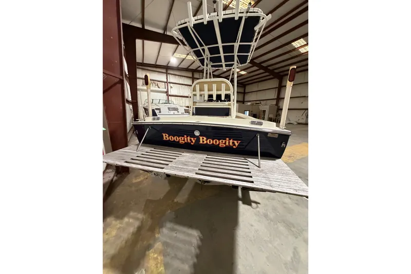 Slide: The Image of 1982 Shamrock 200 Open boat named "Boogity Boogity" in a warehouse setting. - 15