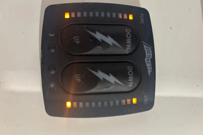 Slide: The Image of Bennett trim tab control panel with illuminated indicators on a Shamrock 200 Open boat. - 5