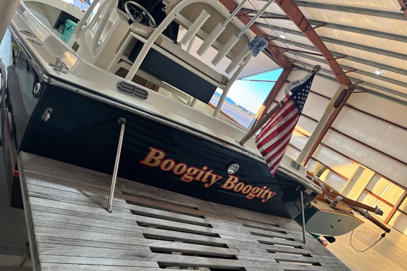 Slide: The Image of 1982 Shamrock 200 Open boat named "Boogity Boogity" in a storage facility with American flag. - 2